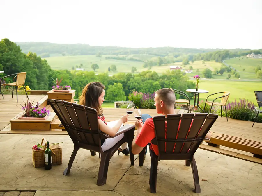 A couple sitting on the terrace, looking out across the valley.